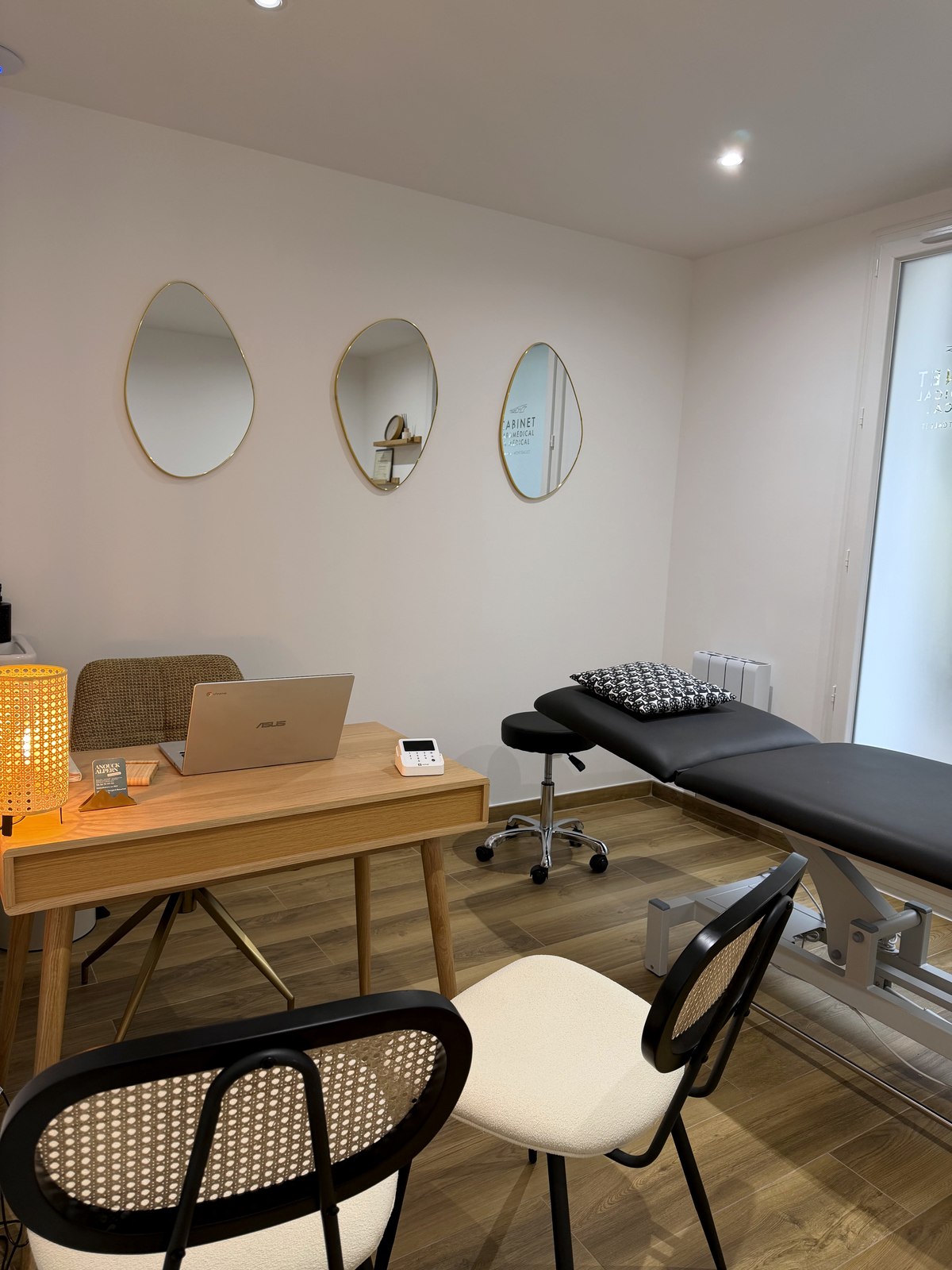 La salle de consultation : table d'ostéopathie, parquet chaleureux, miroirs organiques et lumière naturelle